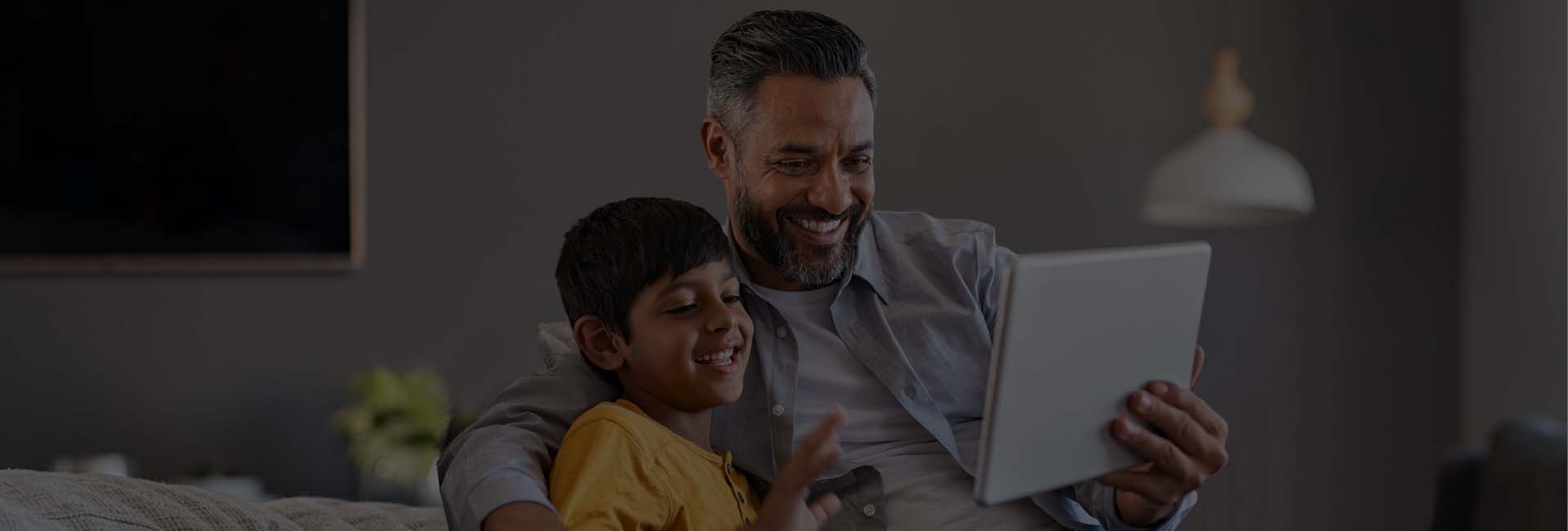 father and son looking at notebook, smiling