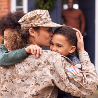 Military mother kissing and hugging children