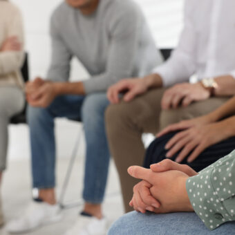 A group of people sitting on chairs in a circle.