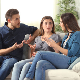Mom and Dad with a child in the middle sitting on the couch